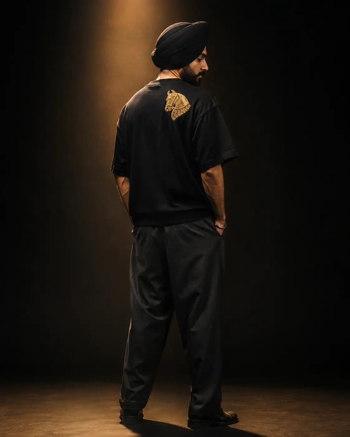 Sikh model wearing the BAAG Shaahi Horse black T-shirt with gold horse embroidery